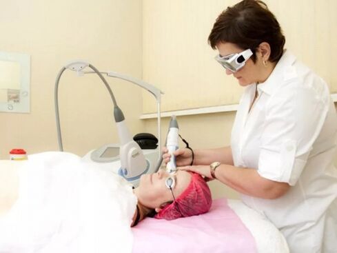 The beautician performs a laser rejuvenation procedure